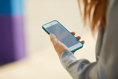 Foto de una mujer usando wi-fi residencial en su smartphone.